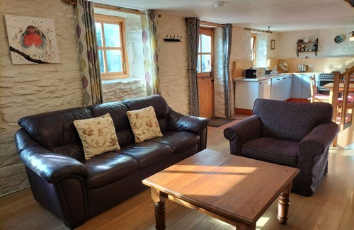 Lampeter Cottage | Un ancien écurie confortable converti avec des murs en pierre et de vieilles poutres tout au long