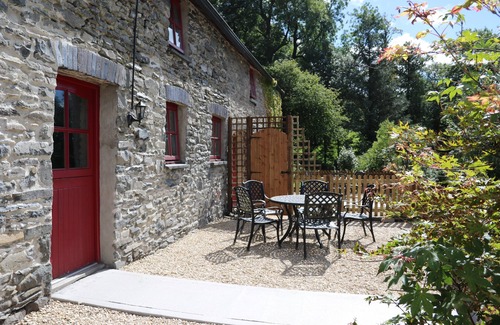 Lampeter Cottage | Un ancien écurie confortable converti avec des murs en pierre et de vieilles poutres tout au long