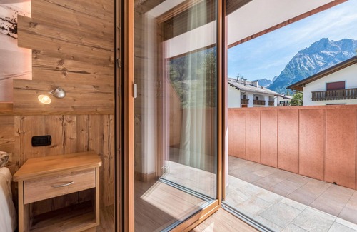 Canazei Appartement | Appartement Ciasa Rosa avec vue sur les montagnes, balcons et jardin partagé.