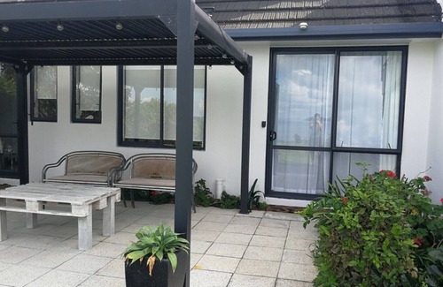 Tawharanui Appartement | Espace boutique confortable dans un emplacement privilégié avec vue sur la mer et le jardin.
