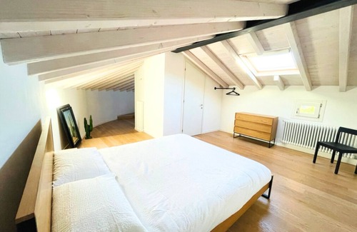 Bassano del Grappa Appartement | Casa Tonde, a modern attic with exposed beams.