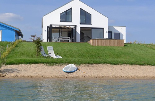 Lobnitz Maison | Maison de vacances spacieuse avec une plage privée, une cheminée à foyer ouvert et un sauna directement sur le lac