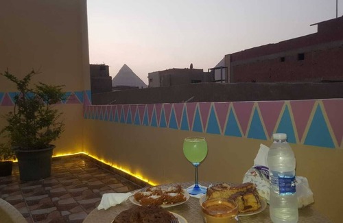 Giza Maison | It's a house .it has aquit roof with a view of pyramids
