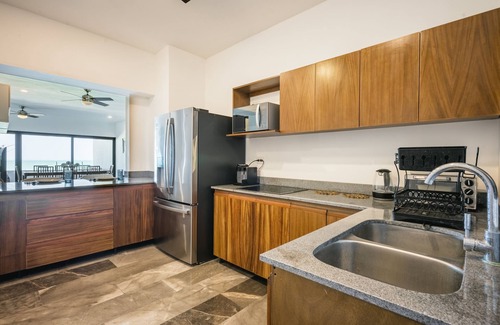 Ixil Appartement | Oceanfront retreat with private balcony, outdoor pool, and stunning views