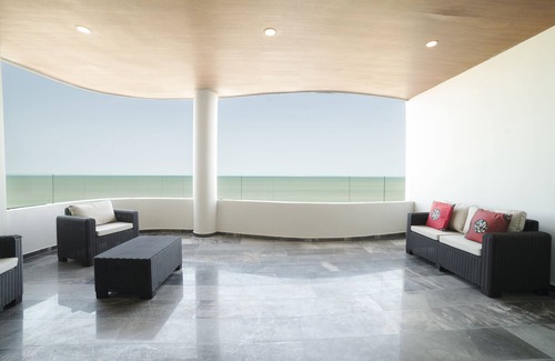 Ixil Appartement | Oceanfront retreat with private balcony, outdoor pool, and stunning views