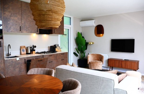 Lieren Maison | osendael: Stylish 4-person home with 2 bedrooms, each with en-suite bathrooms—one with a whirlpool and the other with a shower and sunshower—a hot tub, partially covered outdoor terrace, and modern kitchen. Enjoy luxury in the Veluwe!