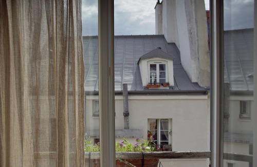 Quartier de la Roquette Appartement | Lumière d'été : nid d'architecte entre les toits
