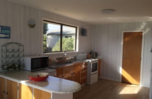 Waikanae Maison | Magnifique maison de vacances avec vue sur l'océan 1 à l'arrière de la plage