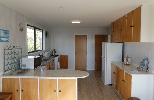 Waikanae Maison | Magnifique maison de vacances avec vue sur l'océan 1 à l'arrière de la plage