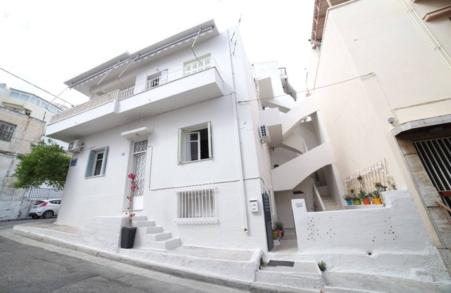 Une maison avec une cour et un balcon, située dans la zone de Filopappou.