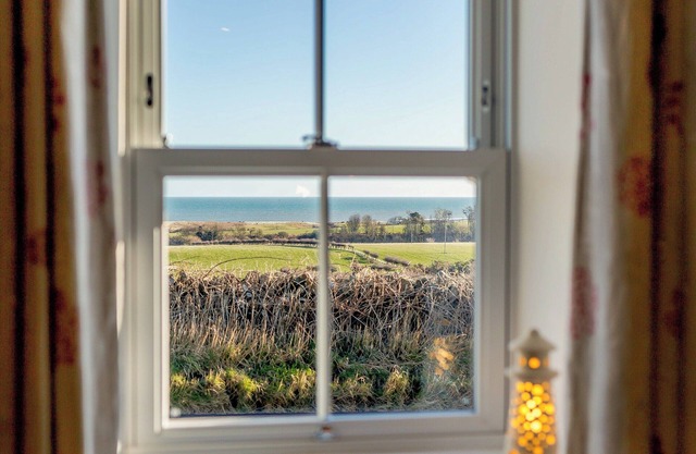 Mid-terraced single storey cottage with lovely views across farmland to the sea on the horizon.