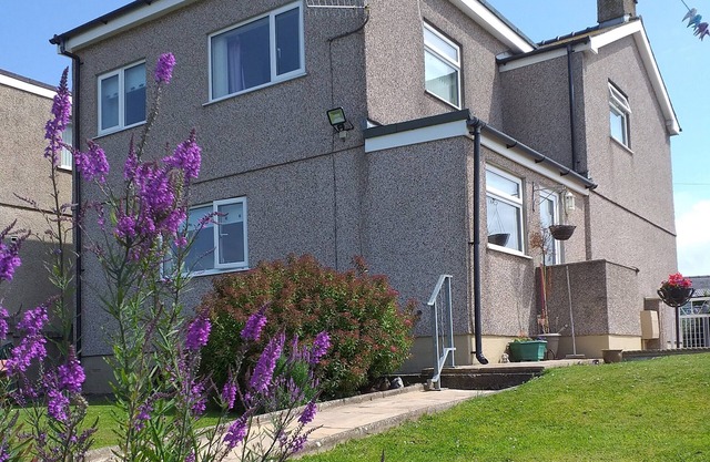 An immaculate spacious house with pretty garden, off road parking and sea views in the distance.