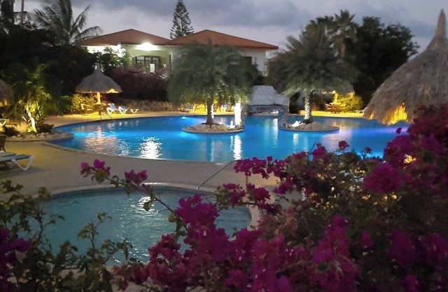 A small mansion with a large swimming pool in a botanical garden