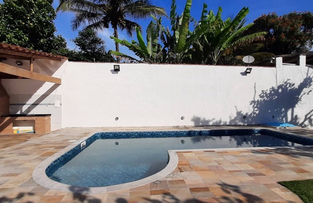 Maison de plage avec piscine et barbecue.