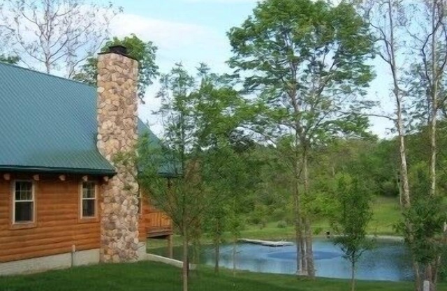 Cabane en rondins de luxe isolée donnant sur un bel étang ensemencé