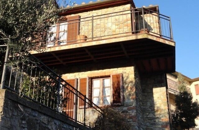 Belle maison en pierre en Toscane avec terrasse et balcon.