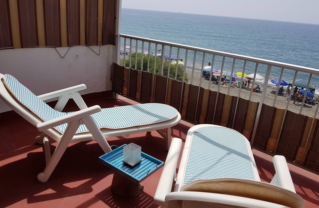 Maison sur la plage avec grande terrasse et vue sur la mer.
