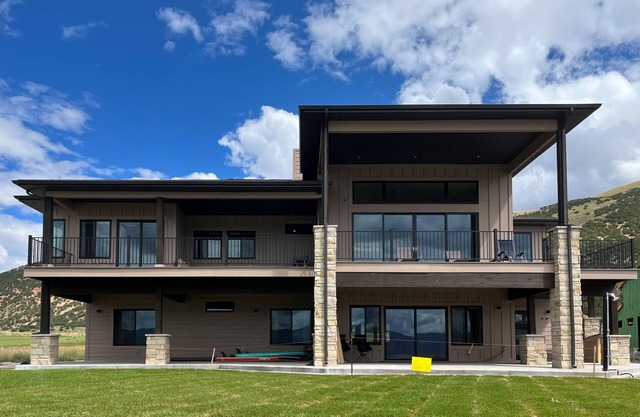 Brand-new lakefront home with private beach, mountain views, fireplace & deck