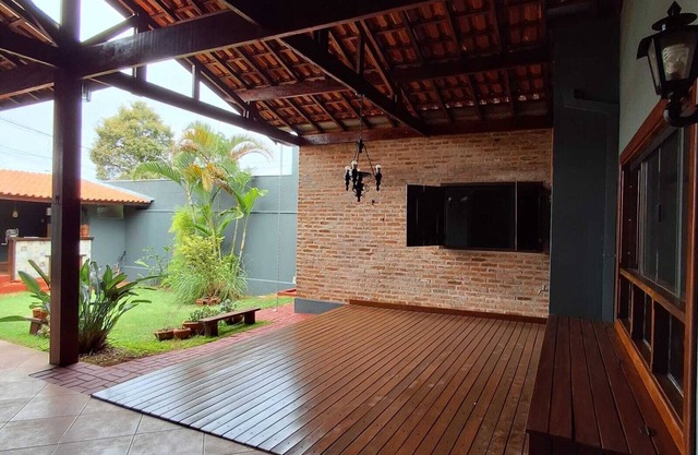 Casa com ares de campo na cidade. Deck com redes e bancos, jardim e quiosque.
