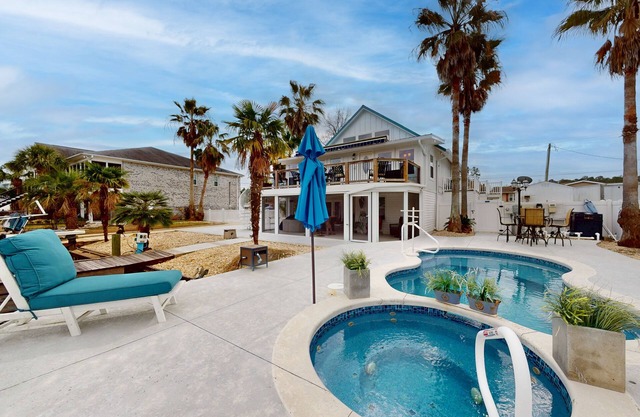 Charming riverfront home with a pool, hot tub, balcony, and boat dock