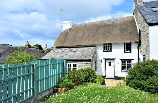 Charming Listed Thatched Cottage with parking and short walk to sandy beach .
