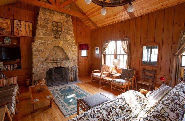 Cabine / chalet classique avec grande véranda, cheminée en pierre, murs de pin noueux