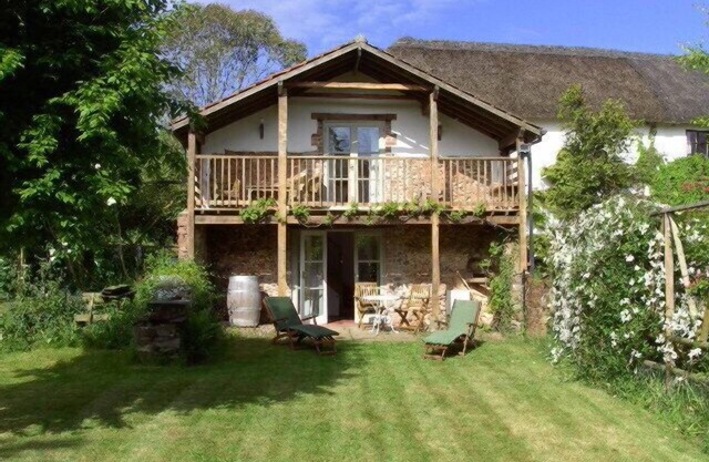 Grange convertie sur le toit de chaume de Devon Longhouse au pied des Rolling Hills.