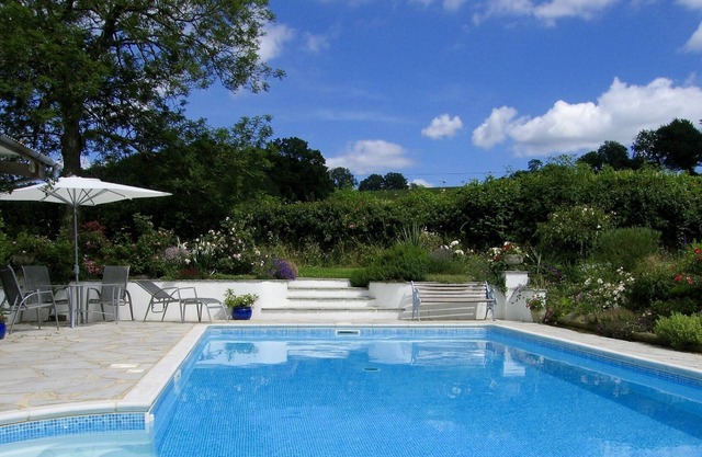 Cottage avec piscine extérieure chauffée dans des jardins dans un endroit paisible avec des vues glorieuses