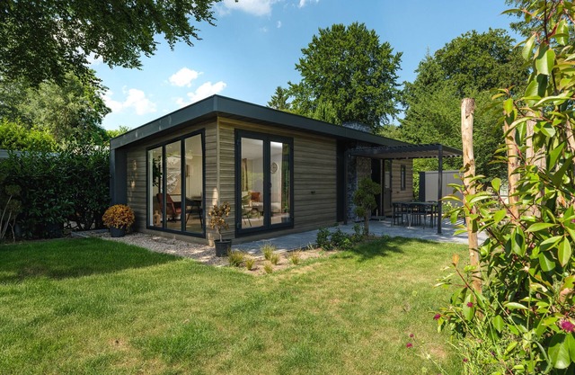 Enjoy a holiday home in the wooded nature of the Veluwe, complete with modern amenities and a stylish pergola for optimal comfort.