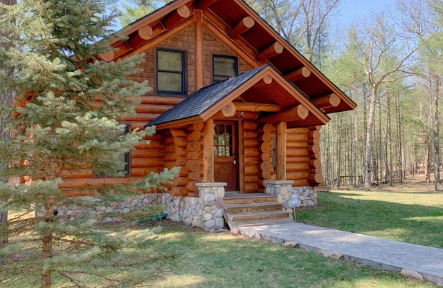 Une cabane en rondins pleine de bois nichée sur les rives du Père Marquette
