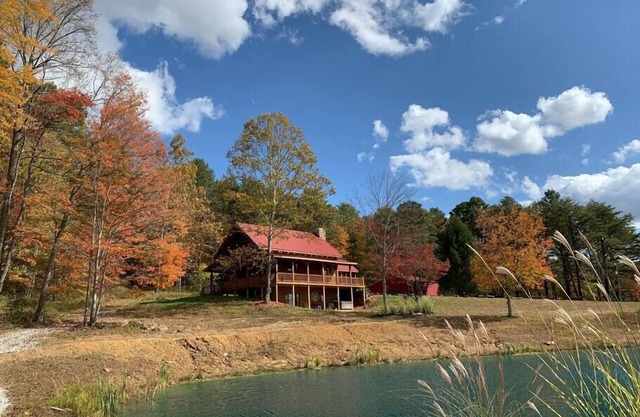 Chalet en rondins isolé sur une colline avec étang de pêche, vue imprenable et sentiers naturels