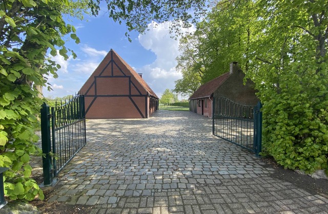 Maison entourée de bois et de prairies