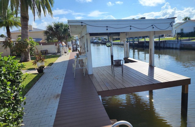 Intercostal channel house with boat dock, above ground pool and ping-pong table