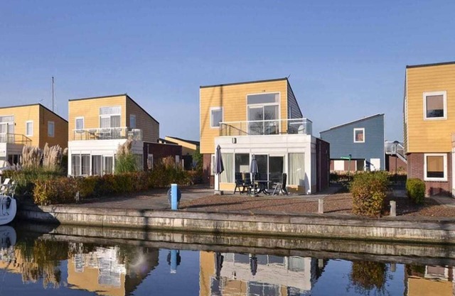 Une maison insulaire avec terrasse fermée sur l’eau. La maison voisine Slaak 65 est aménagée à l’ide