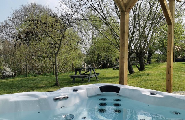 Large three bedroom lodge with private hot tub on the banks of the river Brue.