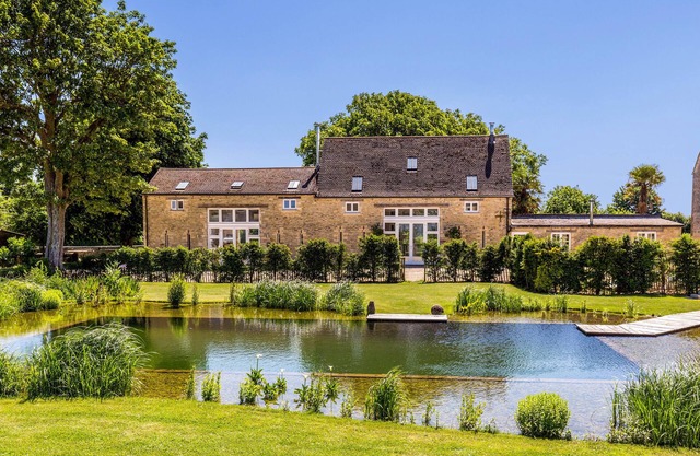 Conversion de grange de luxe sur une ferme rurale des Cotswolds avec étang de baignade