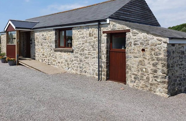Un chalet de plain-pied en pierre avec un espace de vie ouvert et lumineux, un jardin patio et un parking. T
