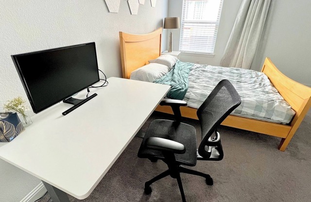 Modern clean guest unit with office setup and washer dryer in unit