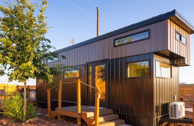 modern tiny home with a hot tub and bbq