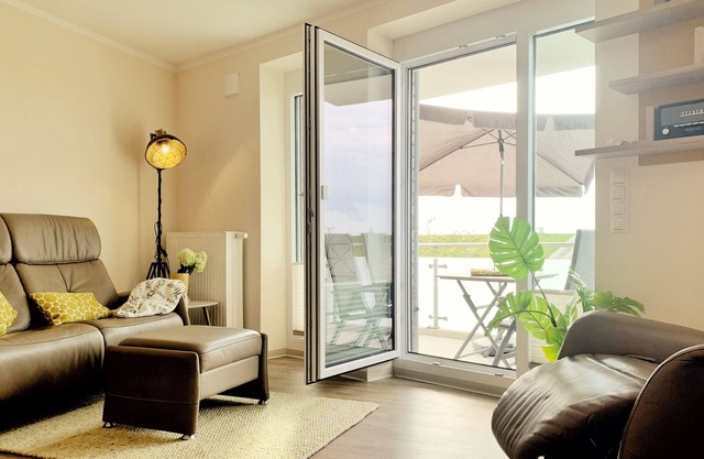 appartement moderne directement sur la digue de la mer du Nord avec une chaise de plage