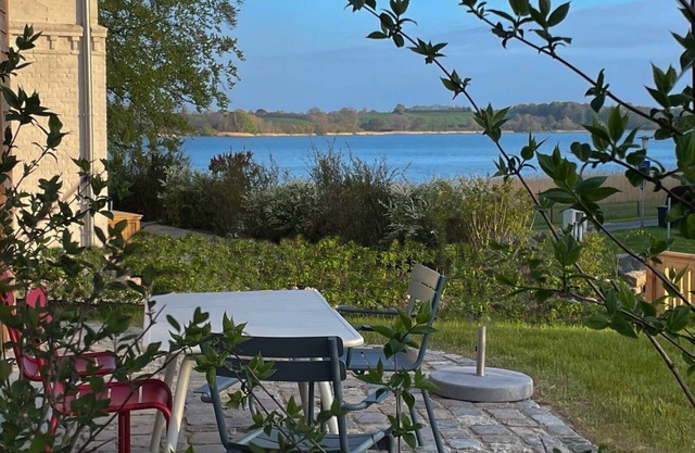 Newly built wooden house "Remise am Fährhaus" with unique architecture directly on the Schlei with jetty and bathing area for your well-deserved vacation in an absolute feel-good atmosphere, with a huge garden area and old trees