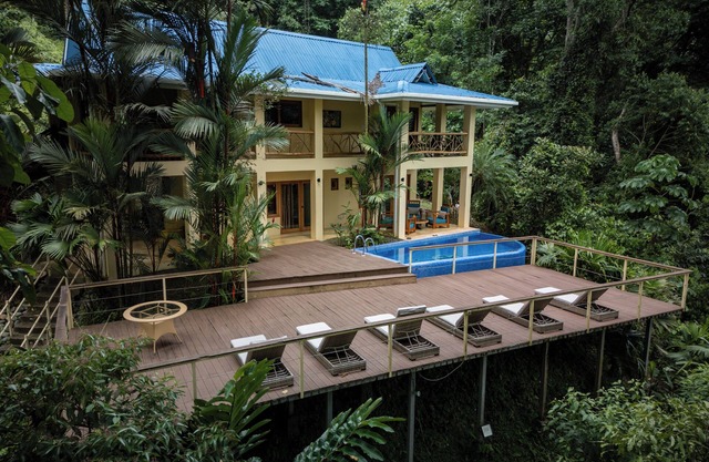 Villa avec piscine privée et vue partielle sur l'océan entourée de forêt tropicale et de cascades
