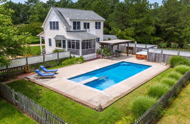 Chalet en bord de mer haut de gamme avec une piscine et un bain à remous pieds de la porte arrière.