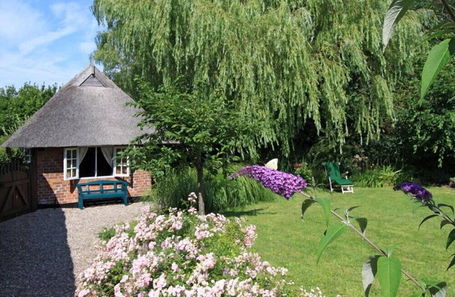 Pittoresque petite maison au toit de chaume, distance de la plage