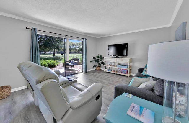 Quite ground-level condo overlooking golf course, short walk to private beach