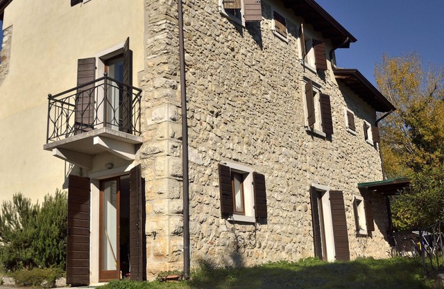 Maison rustique sur colline ensoleillée au centre de cultures agricoles