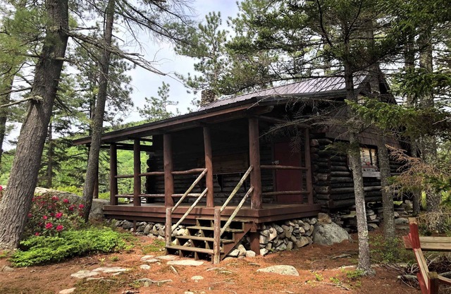 Small private Island on scenic Maine pond with charming authentic log cabin.