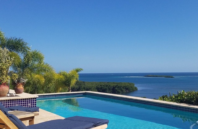 Rainbow Paradise est un 4BR / 3 moderne et magnifique sur le plan architectural. 5 BA maison sur un terrain de 5 acres surplombant les baies de Manglar et Pela. Très isolée et privée. A / C dans BR, ventilateurs de plafond, cuisine complète, piscine ex...