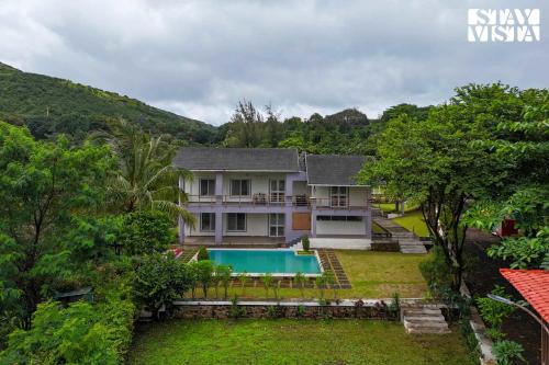 StayVista at Whispers of Green with Lawn and Pool