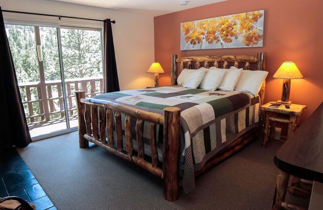 Suite features King bed, full kitchen, and deck with a river view.